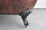 Detail view of brushed nickel foot on copper bronze bathtub